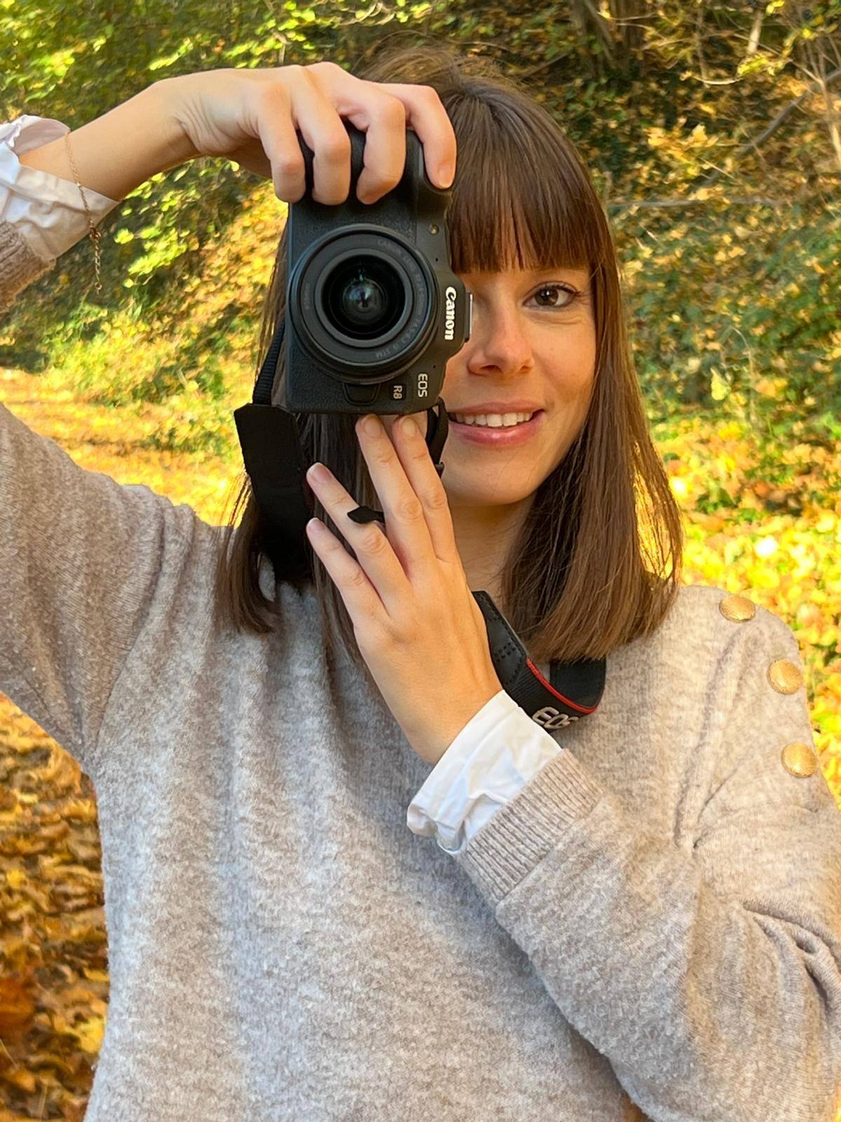 Charlotte, photographe au Versoud, son appareil photo à la main