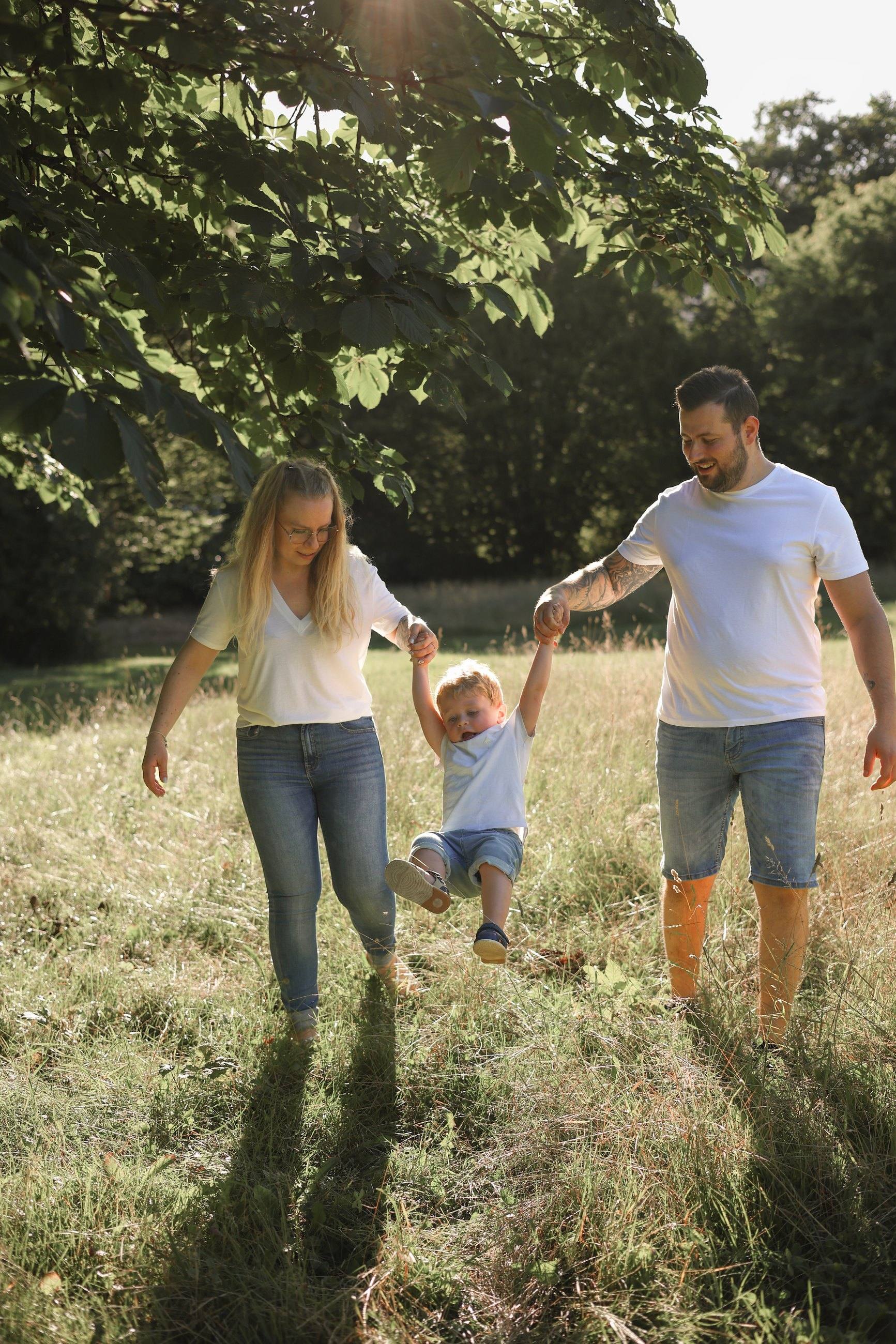 Famille en balade en pleine nature, l’enfant tenu par la main