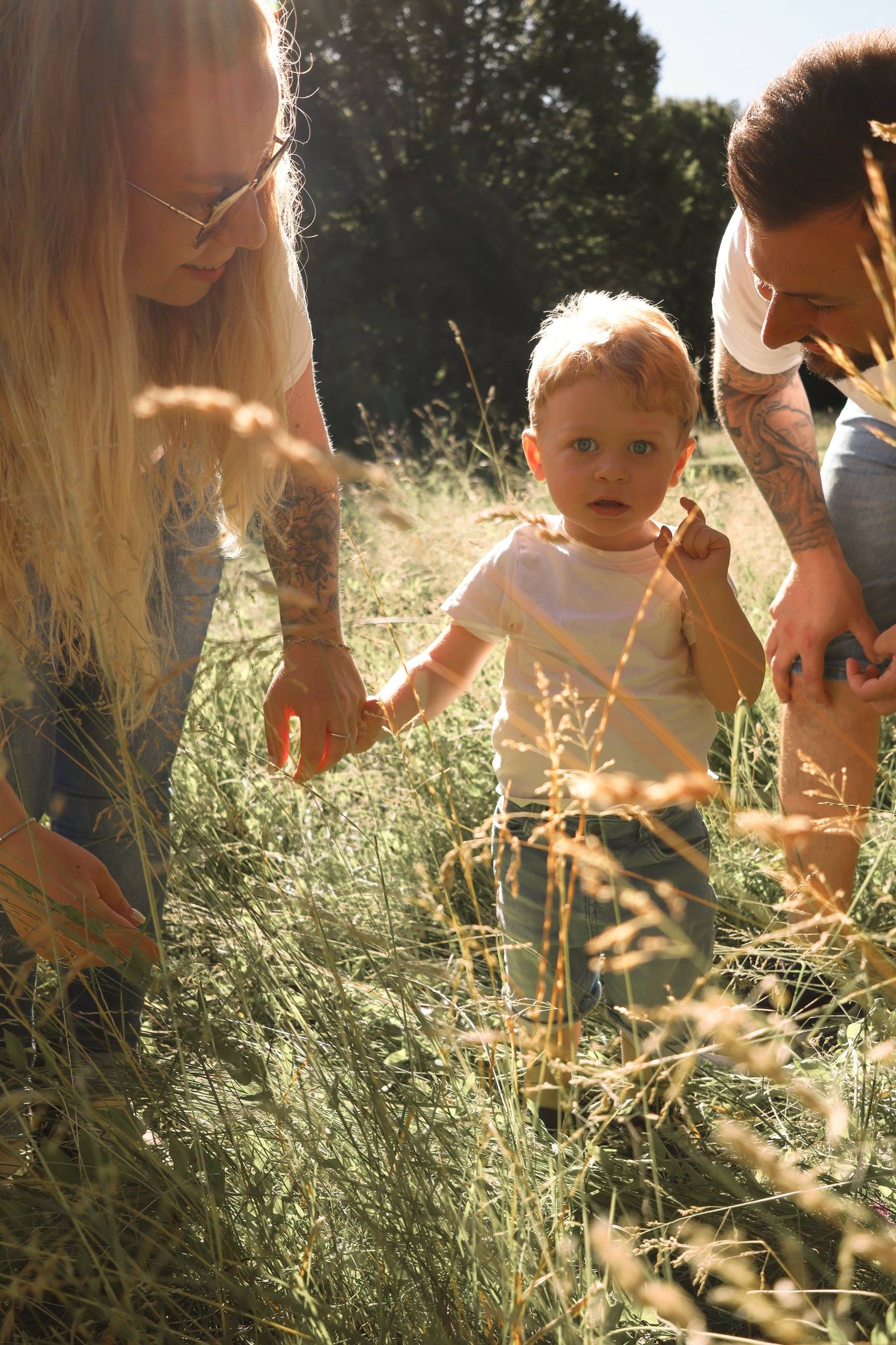 Famille et enfant dans les herbes hautes, lumière dorée