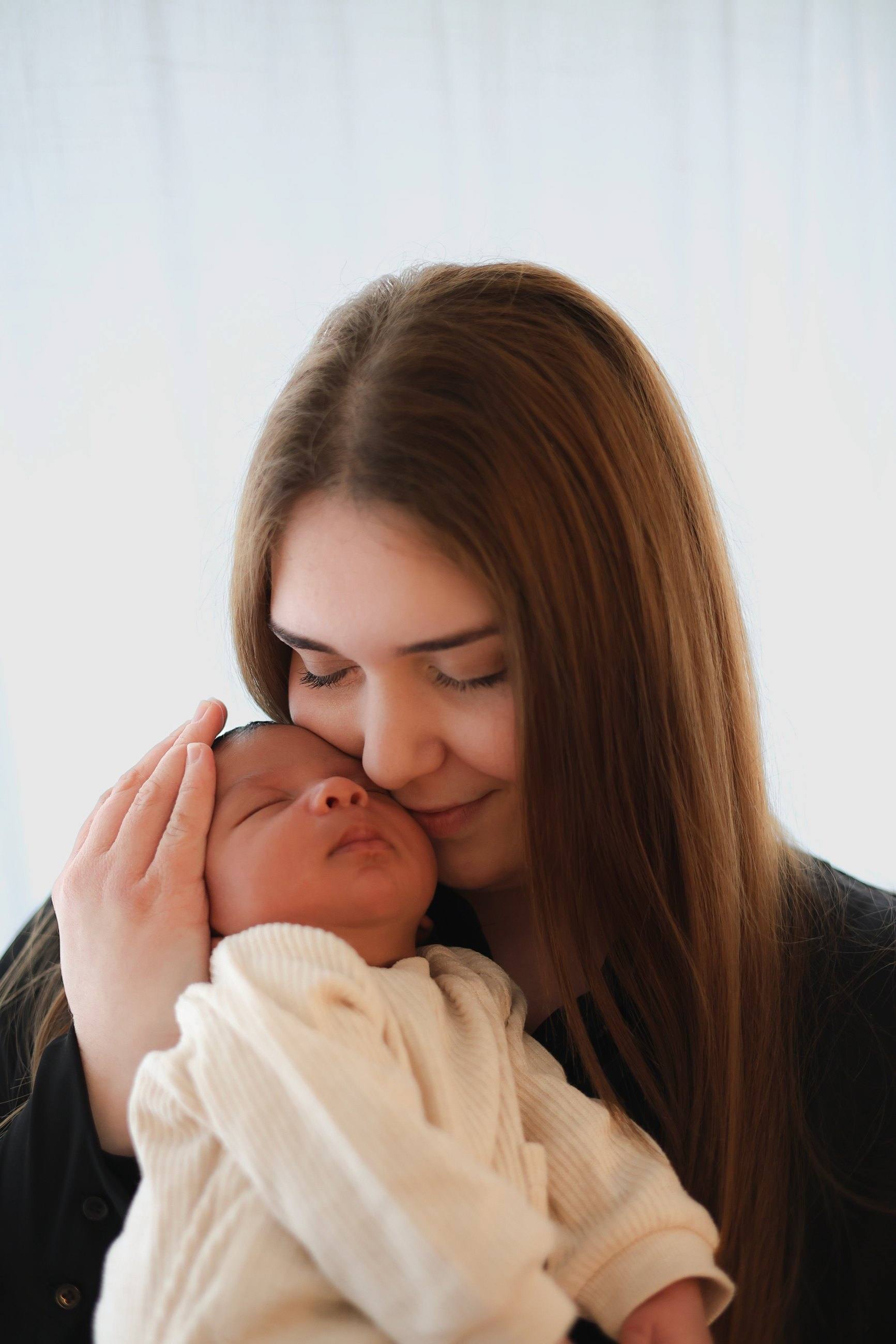 Maman faisant un câlin à son nouveau-né au studio du Versoud