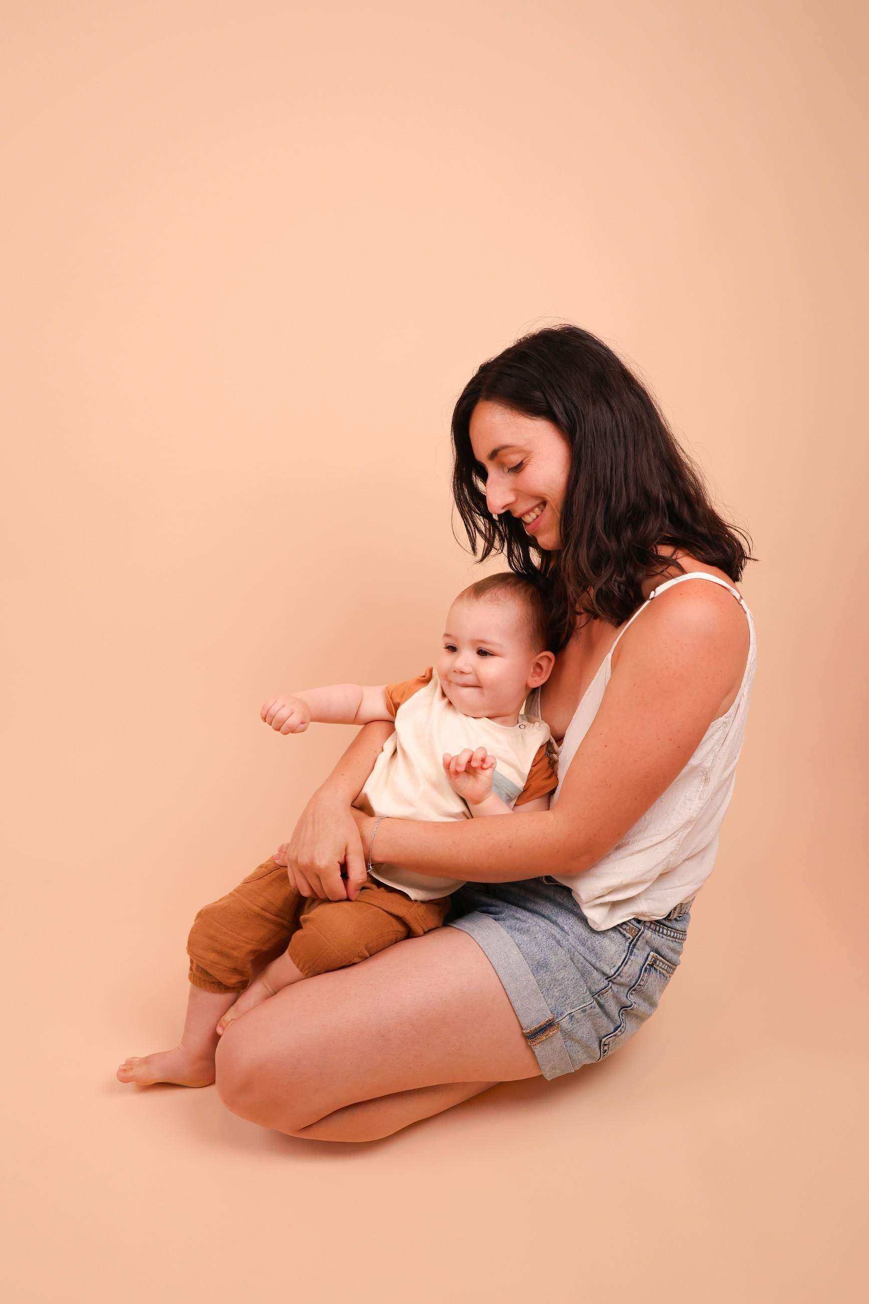 Maman et bébé en studio sur fond pêche