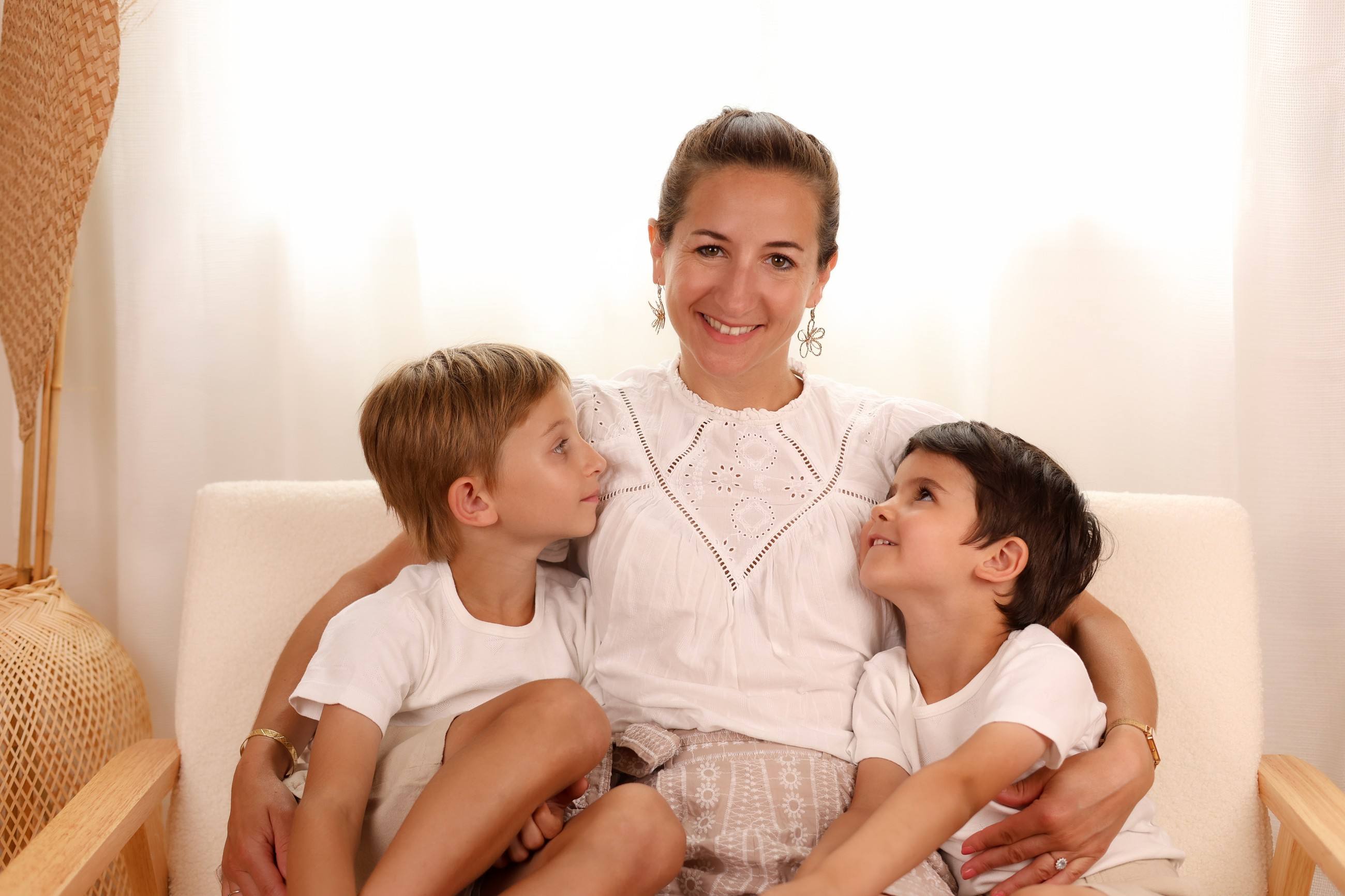 Maman et ses deux fils sur un canapé, séance famille en studio