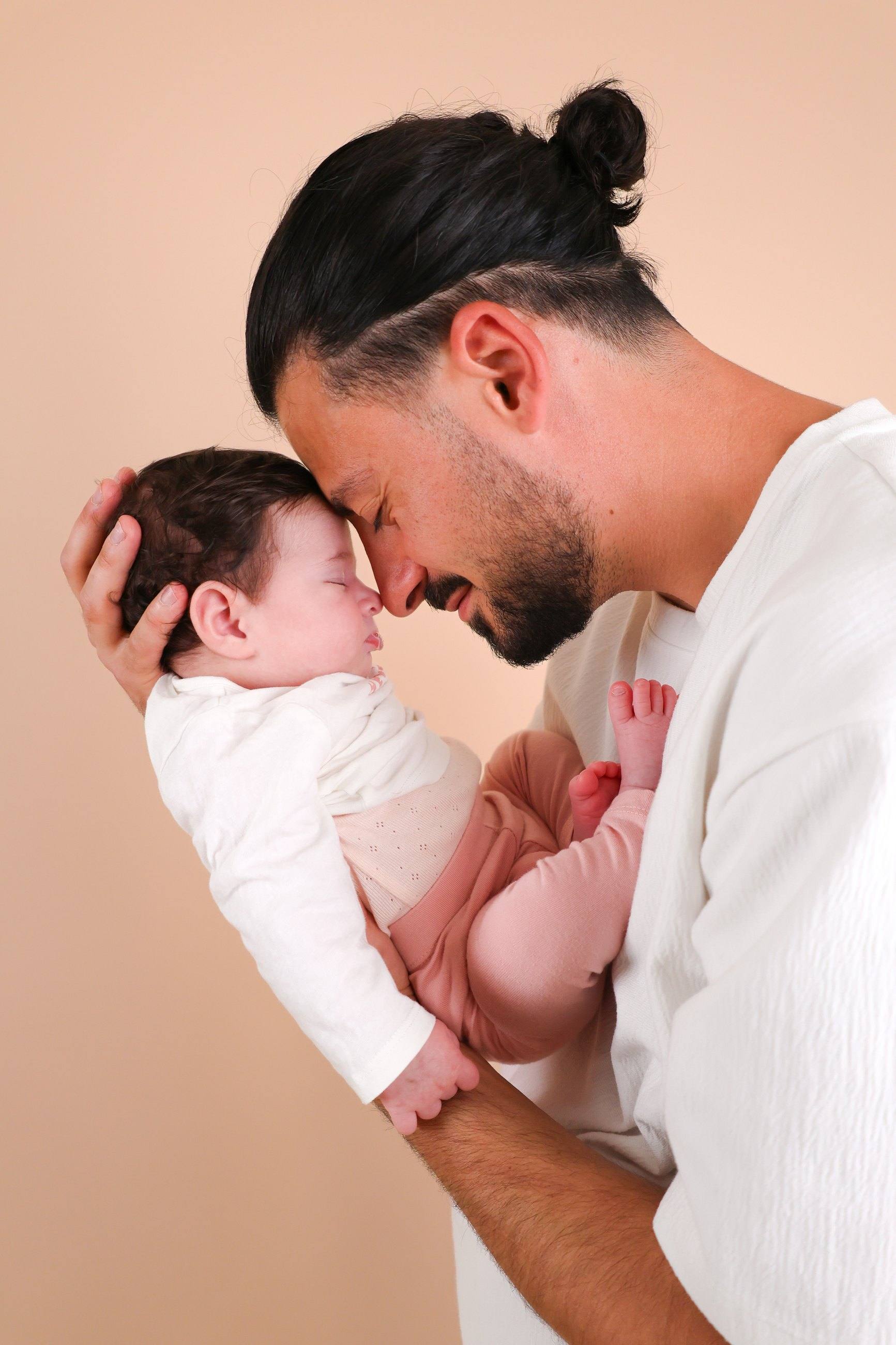 Papa et son nouveau-né sur fond pêche